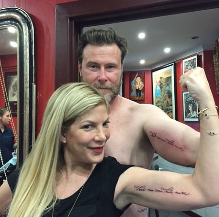 A picture of Tori Spelling with her husband flaunting their matching tattoos.